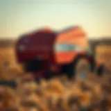 A compact square baler attached to a small tractor in a field